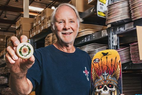 George Powell holds a Powell Peralta Dragon Formula Wheel and a Bones Brigade skateboard deck at the company's Ventura, California factory