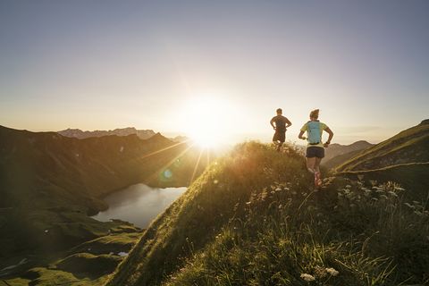 germany, allgaeu alps, man and woman running on mountain trail