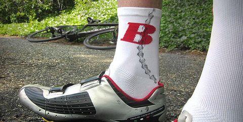 wielrenner met een smeervlek op zijn witte sok