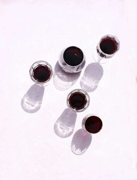 Glasses of red wine on pink background, top view