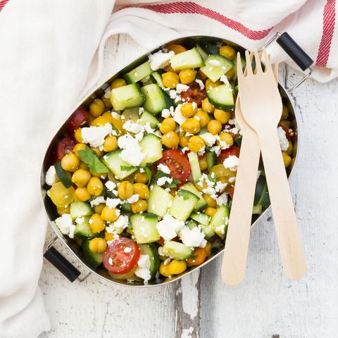 Lunch box of salad with chick peas roasted with curcuma, feta, cucumber, tomatoes and parsley