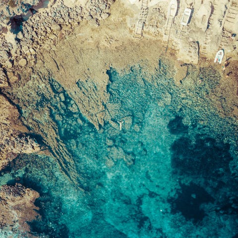 Aerial view of a woman floating in the Mediterranean coast