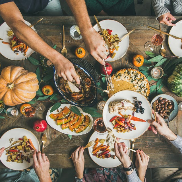 Flat-lay of friends feasting at Thanksgiving Day table with turkey Flat-lay of friends feasting at Thanksgiving Day table with turkey