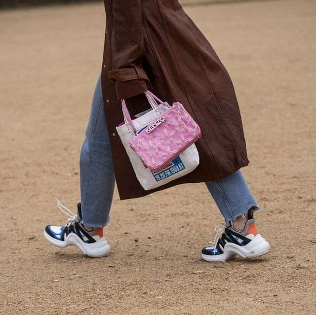 paris, france   january 20 fiona zanetti, wearing a white t shirt, blue jeans, louis vuitton sneakers, pink kenzo bag and brown long coat, is seen in the streets of paris after the kenzo show on january 20, 2019 in paris, france photo by claudio laveniagetty images