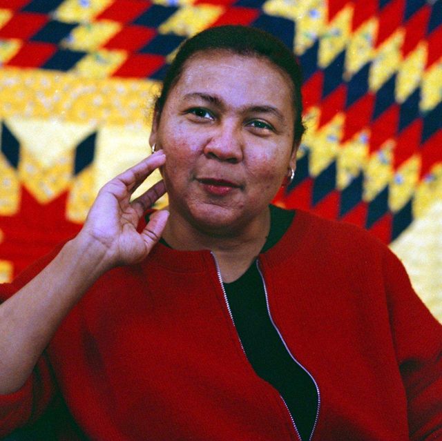 the feminist writer bell hooks, wearing a red jacket with her hand near her face, in a 1999 portrait