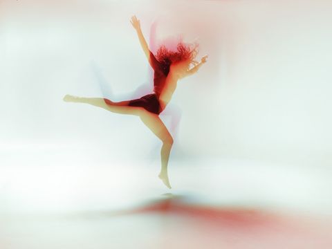 female dancer moving gracefully and powerful in a bright colorfull room, long time exposure