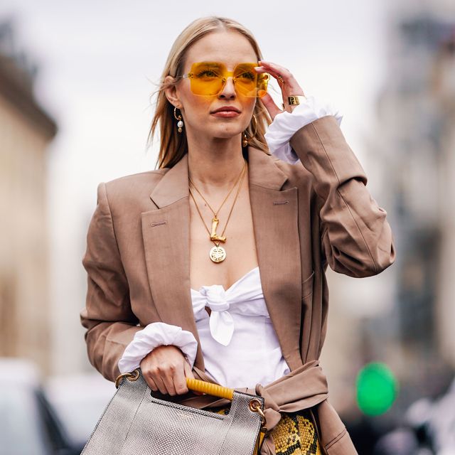 paris, france   march 02 leonie hanne wears yellow sunglasses, a blazer jacket, a golden necklace, a white top, a yellow pvc snake print skirt, a gray bag, black boots, outside elie saab, during paris fashion week womenswear fallwinter 20192020, on march 02, 2019 in paris, france photo by edward berthelotgetty images