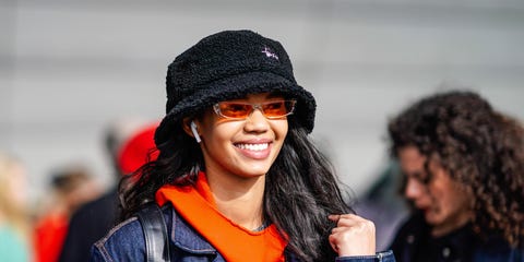 paris, france   march 04 a model wears a black hat, an airpod, an orange top, a denim jacket, apple airpods outside giambattista valli, during paris fashion week womenswear fallwinter 20192020, on march 04, 2019 in paris, france photo by edward berthelotgetty images