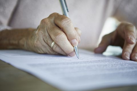 Senior woman's hand signing a document, close-up