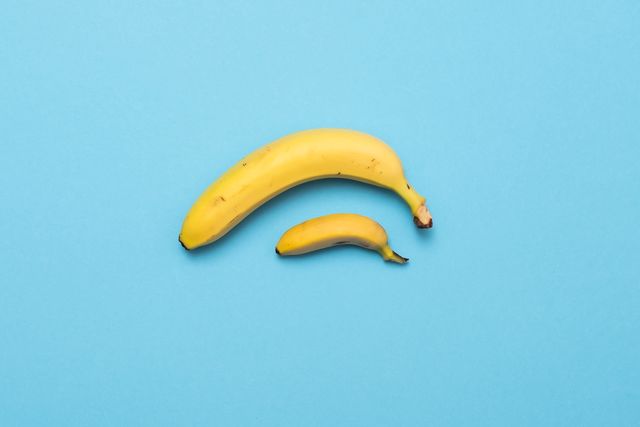 baby banana compare size with banana on blue background representing penis size