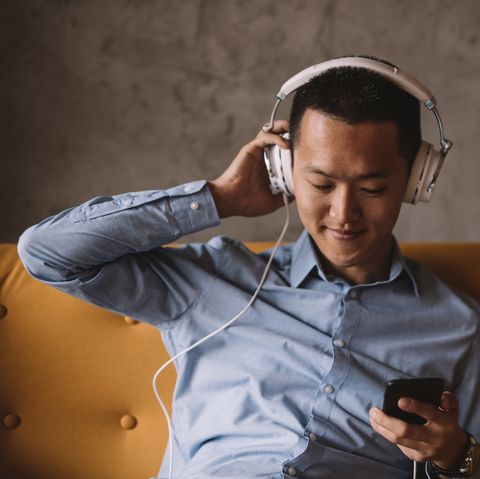 young asian man listening to music and relaxing in his office