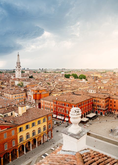 modena, cityscape from a unique point of view, a public raised terrace above the city emilia romagna, italy cloudscape and colorful piazza roma, with ghirlandina tower in background