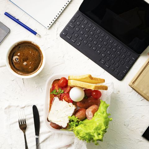 top view of the office work place with computer or laptop pen and phone, nutritious lunch during the works