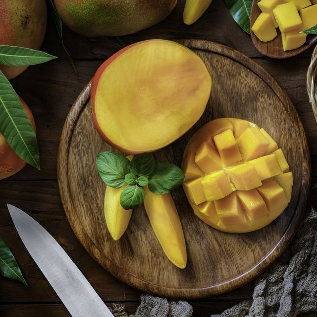 healthy eating themes tropical fruits sliced mangos in a wooden plate on a table in rustic kitchen