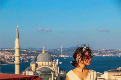 eurasian woman standing at the roof with bosphorus background in istanbul, turkey