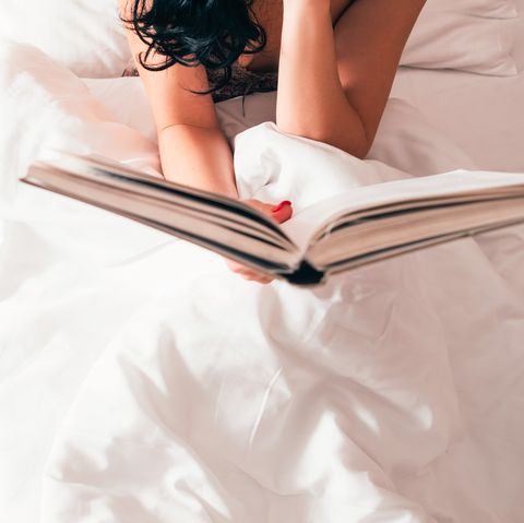 home weekend leisure and hobby cropped top view of brunette lady reading book in bed