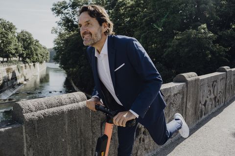 businessman with e scooter on a bridge