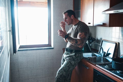 shot of a young soldier eating a snack in the kitchen men's health military diet