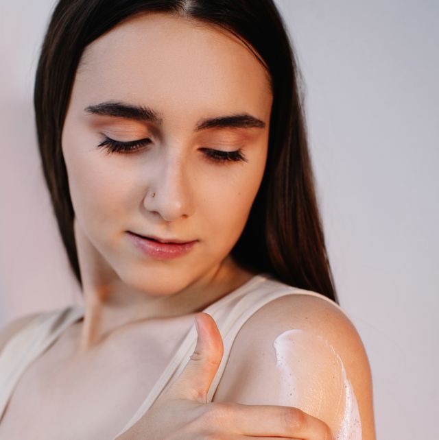 Woman rubbing cream on her arm