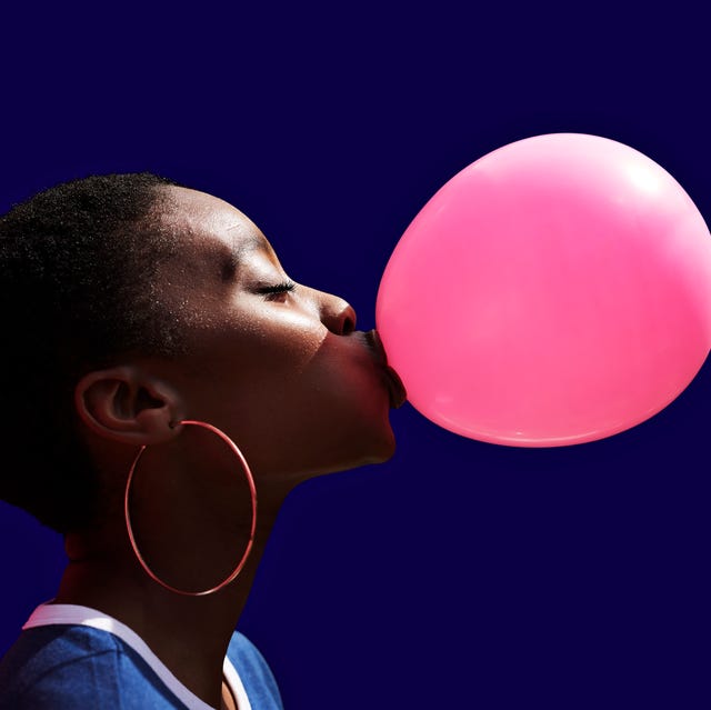 Side view of young woman blowing balloon side view of young woman blowing balloon against blue background