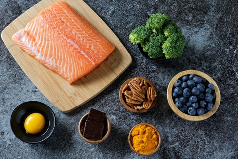 healthy nootropic food including salmon, broccoli, blueberries, nuts, turmeric, dark chocolate, and egg yolk