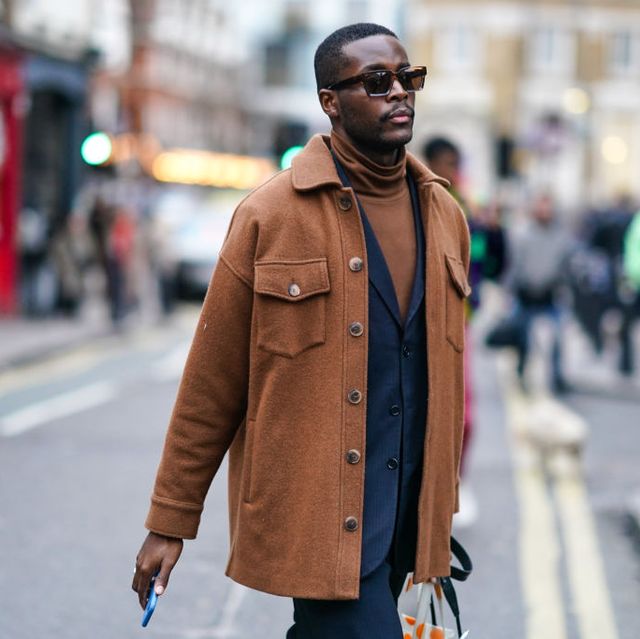 london, england   january 04 a guest wears sunglasses, a brown jacket, a brown turtleneck pullover, a navy blue blazer jacket, blue pants, during london fashion week mens january 2020 on january 04, 2020 in london, england photo by edward berthelotgetty images