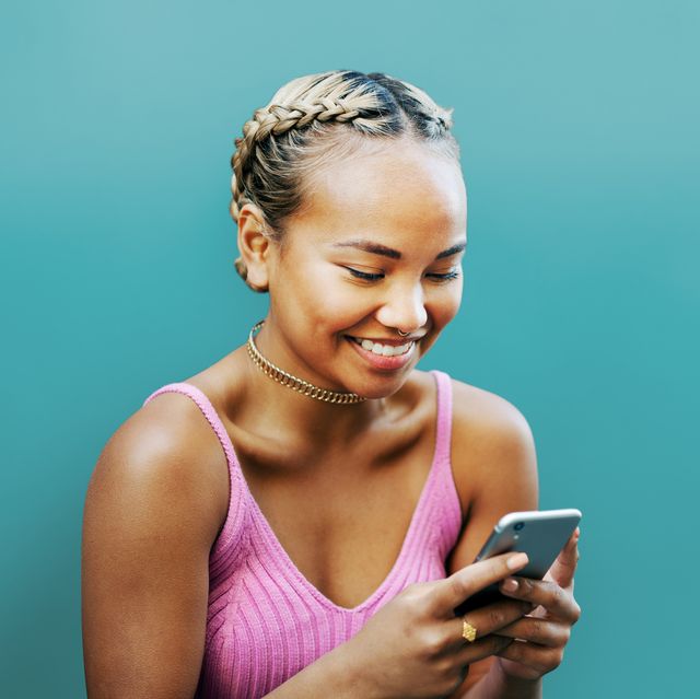 woman smiling with smart phone, blue wall
