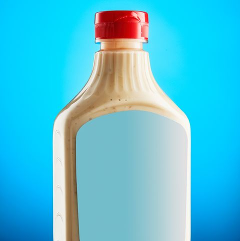 horseradish mustard sauce in plastic bottle with blank label against blue background