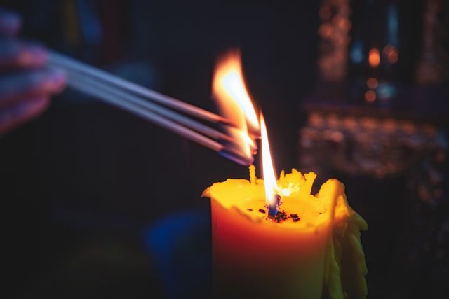 lighting a candle with long matches in the dark