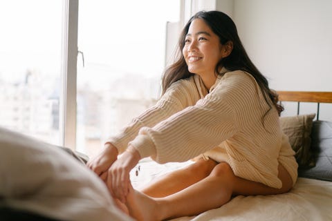 a young woman is stretching her legs for the rest of the day on her bed