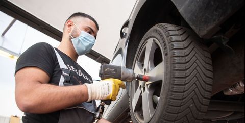 27 april 2020, baden wuerttemberg, stuttgart an employee of a car repair shop wearing a face mask is changing a tire on a car in car repair shops, the tyre change is carried out for the summer season photo marijan muratdpa photo by marijan muratpicture alliance via getty images