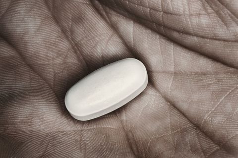 Single pill in man's hand, close-up