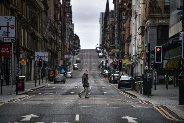 glasgow, scotland   april 01 a man crosses the empty st vincent street during the coronavirus crisis on april 1, 2020 in glasgow, scotland the coronavirus covid 19 pandemic has spread to many countries across the world, claiming over 40,000 lives and infecting hundreds of thousands more photo by jeff j mitchellgetty images