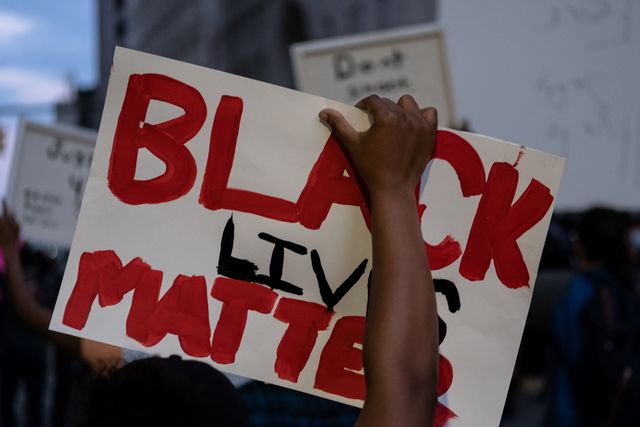 topshot   a person holds up a placard that reads, black lives matter during a protest in the city of detroit, michigan, on may 29, 2020, during a demonstration over the death of george floyd, a black man who died after a white policeman knelt on his neck for several minutes   violent protests erupted across the united states late on may 29, over the death of a handcuffed black man in police custody, with murder charges laid against the arresting minneapolis officer failing to quell boiling anger photo by seth herald  afp photo by seth heraldafp via getty images