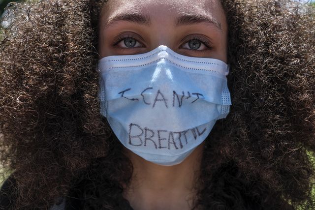 mujer con máscara de protesta por el movimiento black lives matter