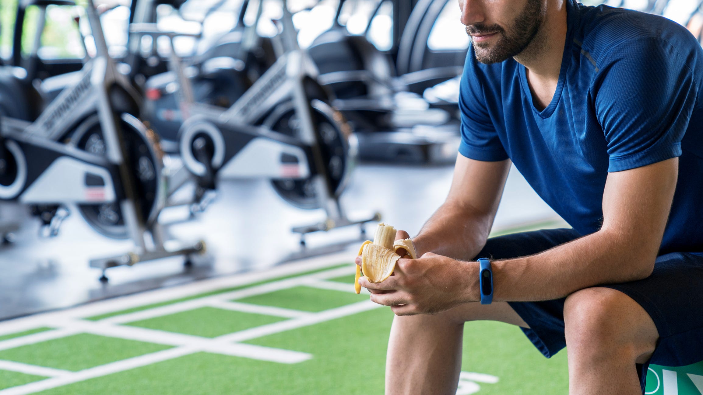 Athletes dressed in blue eat bananas after exercise