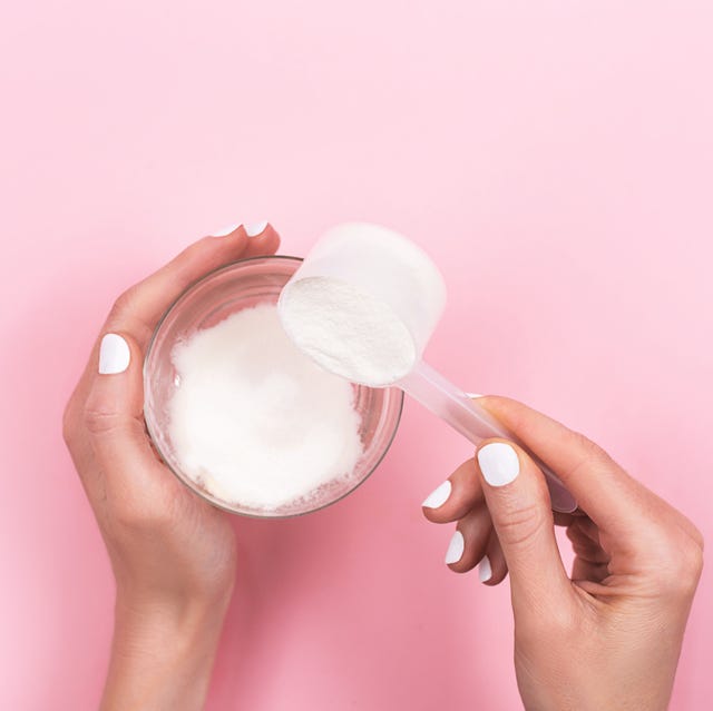 woman hands with a scoop with collagen or protein powder and a glass of water trendy beauty supplement for healthy skin and bones flatlay, top view