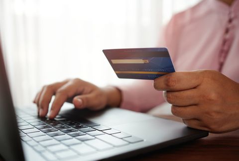 hands holding a credit card and using the laptop for online shopping and online payment via the internet technology concept
