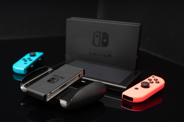 nintendo switch console with joy cons, tv connector and controller accessories