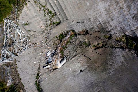 this aerial view shows the damage at the arecibo observatory after one of the main cables holding the receiver broke in arecibo, puerto rico, on december 1, 2020   the radio telescope in puerto rico, which once starred in a james bond film, collapsed tuesday when its 900 ton receiver platform fell 450 feet 140 meters and smashed onto the radio dish below photo by ricardo arduengo  afp photo by ricardo arduengoafp via getty images