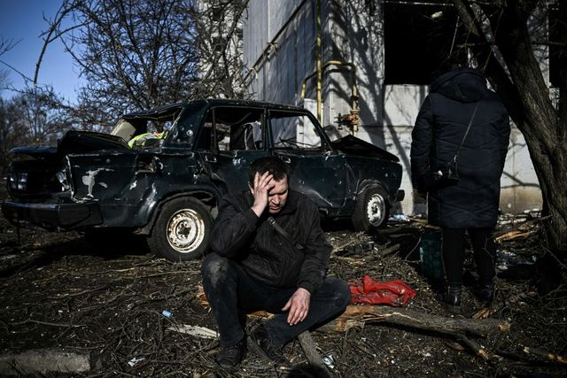 topshot   a man sits outside his destroyed building after bombings on the eastern ukraine town of chuguiv on february 24, 2022, as russian armed forces are trying to invade ukraine from several directions, using rocket systems and helicopters to attack ukrainian position in the south, the border guard service said   russias ground forces today crossed into ukraine from several directions, ukraines border guard service said, hours after president vladimir putin announced the launch of a major offensive russian tanks and other heavy equipment crossed the frontier in several northern regions, as well as from the kremlin annexed peninsula of crimea in the south, the agency said photo by aris messinis  afp photo by aris messinisafp via getty images