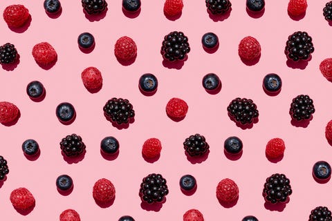 pattern of raspberries, blueberries and blackberries against pink background