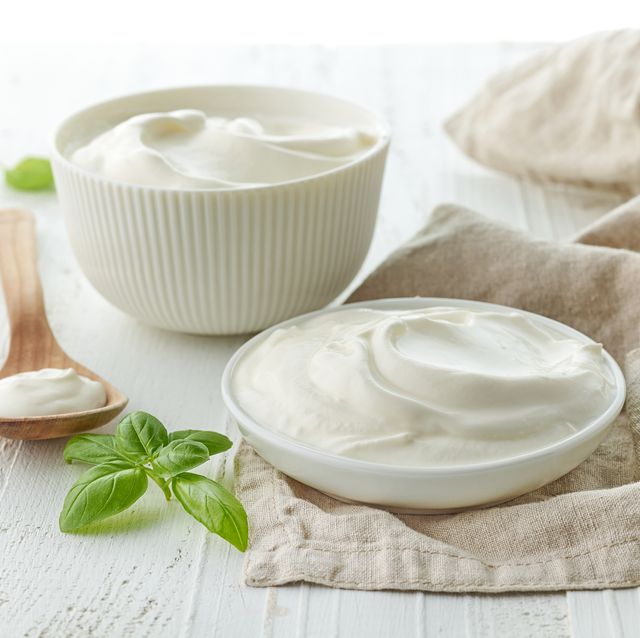 bowls of sour cream or yogurt on white wooden table