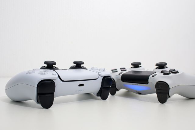 riga, latvia   november 23, 2020 sony playstation 5 and sony playstation 4 controllers on white background