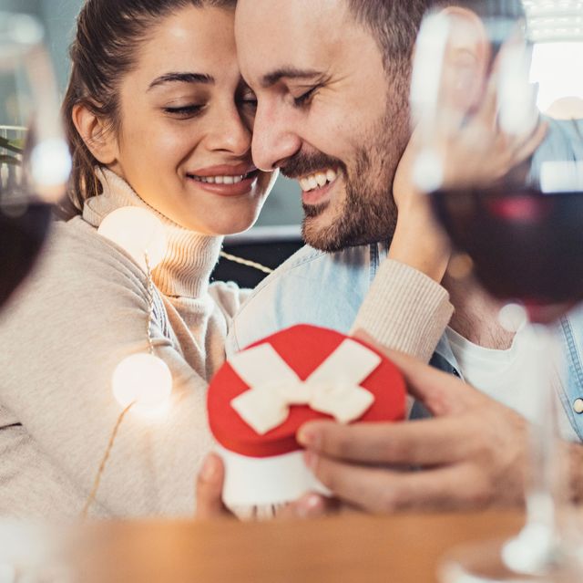 man and woman on valentines day with wine and gifts