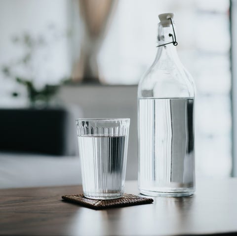 a glass of water served on the coffee table next to a bottle of water in the living room at home healthy lifestyle and stay hydrated