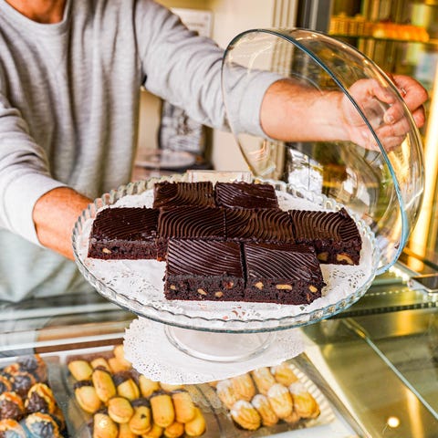 man dispensing cakes in a pastry bakery