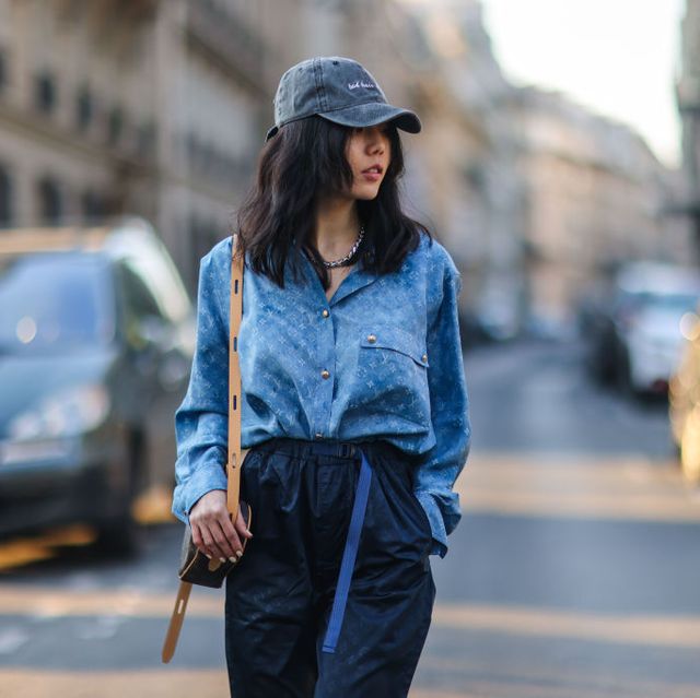paris, france   march 07 xiayan aka gxiayan wears a cap hat, a blue monogram printed shirt from louis vuitton, a brown heart shaped vuitton monogram printed bag, dark navy blue monogram printed vuitton pants, on march 07, 2021 in paris, france photo by edward berthelotgetty images