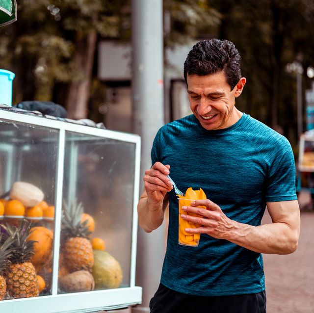 the athlete buys a fruit salad from a local vendor