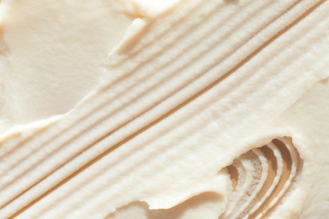 appetizing textured brush strokes of vanilla ice cream or lemon sorbet on beige background flat lay style